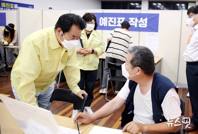 백군기 용인시장이 17일 기흥구 코로나19 예방접종센터를 방문해 시민과 이야기를 나누고 있다.(용인시 제공)