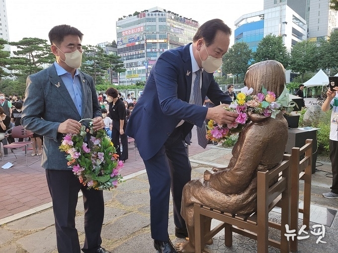 이권재 오산시장과 성길용 오산시의회 의장이 오산평화의소녀상에게 헌화하고 있다.(사진=오산시)