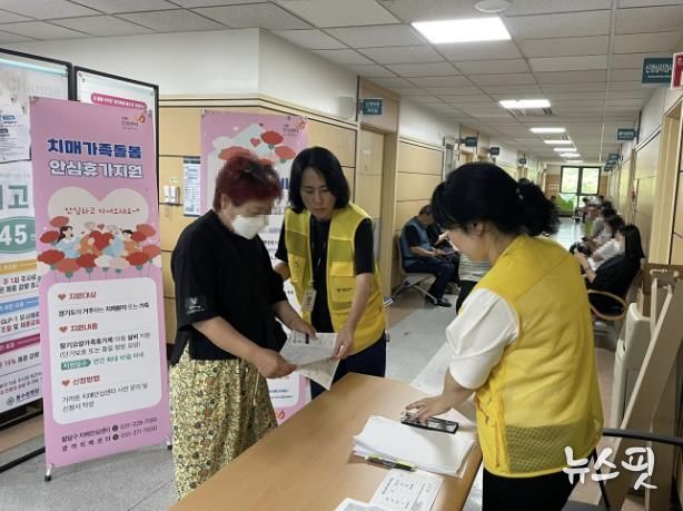 치매안심센터 직원이 의료시설에서 치매 사업을 안내하고 있다