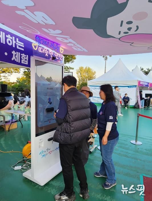 지난 25일 '안산페스타 2025'에 참여한 한 시민이 행사장에서 운영중인 나눔 키오스크를 이용, 기부에 참여하고 있다.