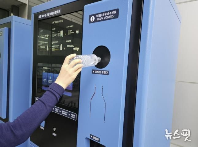 수원시 관계자가 투명페트병 무인회수기에 페트병을 투입하고 있다.