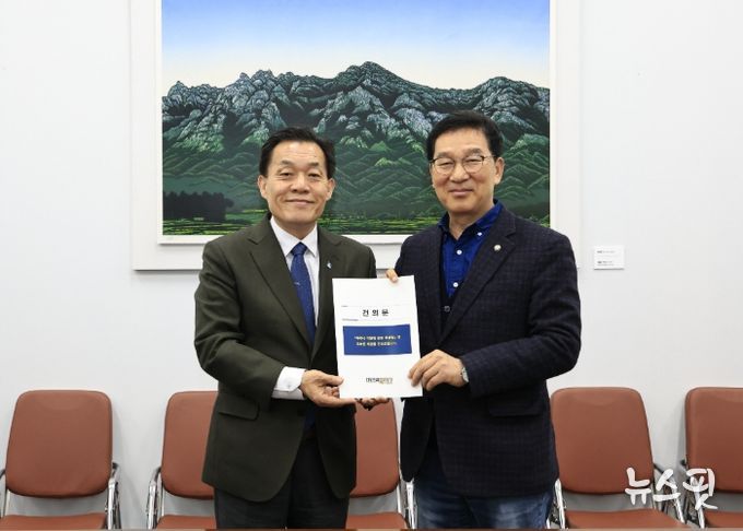 이재준 수원시장(왼쪽)이 신정훈 국회 행정안전위원장에게 건의문을 전달하고 있다.