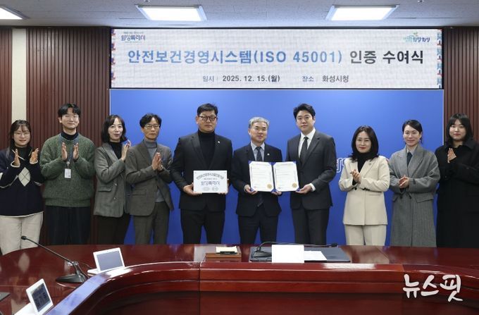 정구원 화성특례시 제1부시장 및 안상현 ISO 45001 선임 심사원 등 관계자가 안전보건경영시스템 인증식에서 기념 촬영을 하고 있다.(화성시 제공)