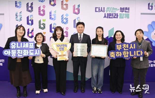 조용익 부천시장과(오른쪽 네 번째), 허정원 아동친화도시조성 추진위원회 부위원장(오른쪽 다섯 번째), 이서현 아동참여위원회 위원장(오른쪽에서 세 번째), 정애경 복지국장(오른쪽 두 번째), 아동보육과 직원들이 유니세프 아동친화도시 인증 기념사진을 찍고 있다.