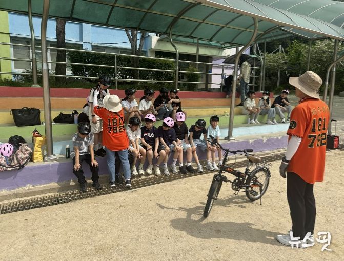 학교 운동장에서 학생들이 자전거 보호장구 착용 요령 교육을 받고 있다.