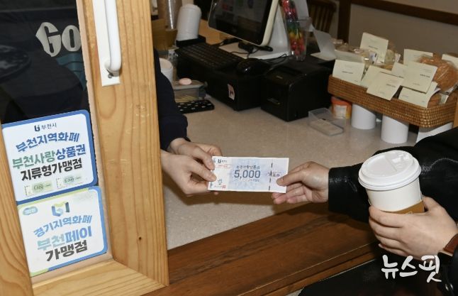 지류형 부천사랑상품권으로 음료를 구입하고 있는 모습